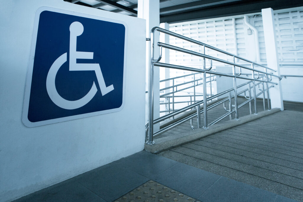 Rampe en béton avec main courante en acier inoxydable avec panneau pour personnes handicapées pour aider les personnes handicapées en fauteuil roulant.
